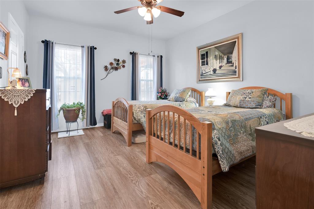 201 East Walker Street Denison, TX 75021 - Photo 10 of 19 a bedroom with two beds and a chandelier