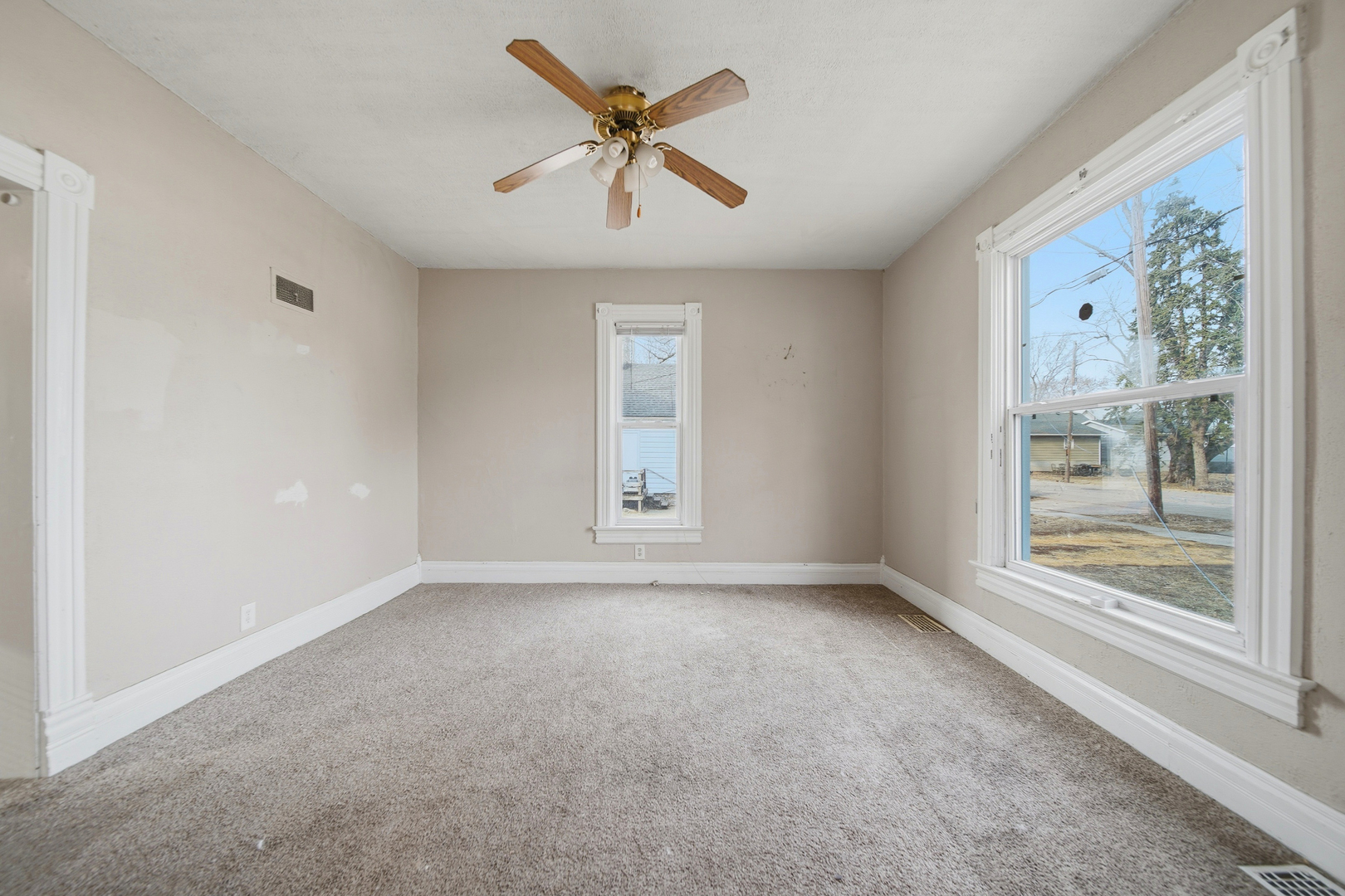 119 Douglas Avenue Dixon, IL 61021 - Photo 4 of 17 an empty room with windows and ceiling fan