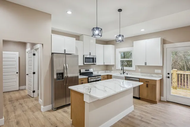 a kitchen with a refrigerator a sink and wooden floor
