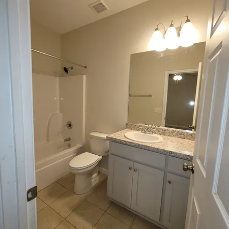 a bathroom with a granite countertop sink a toilet and shower