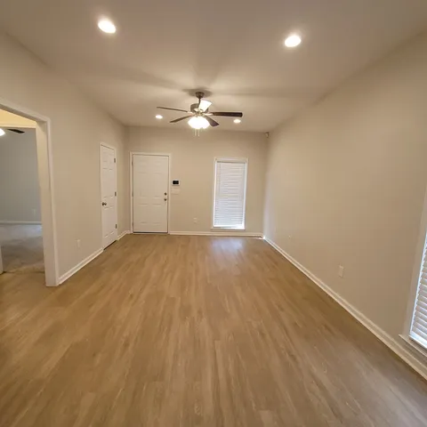 a view of empty room with wooden floor