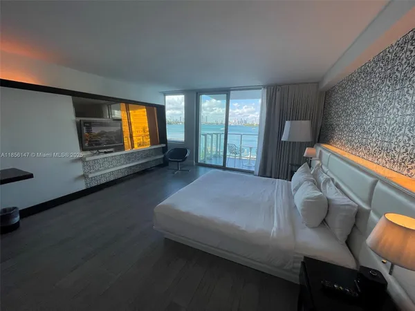 a spacious bedroom with a bed and wooden floor