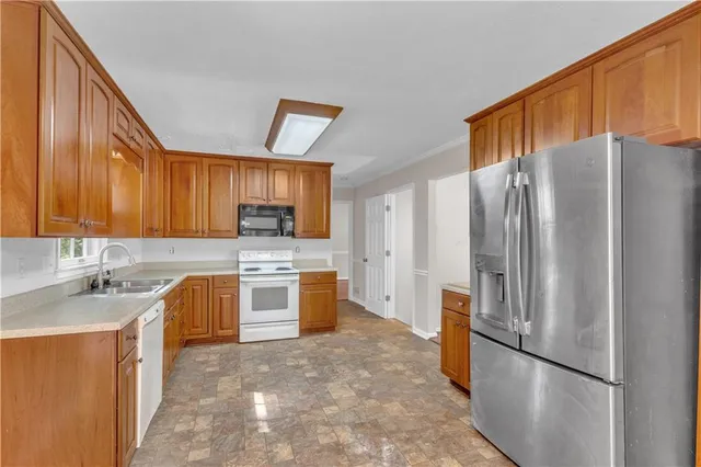 a kitchen with stainless steel appliances granite countertop a refrigerator stove and sink