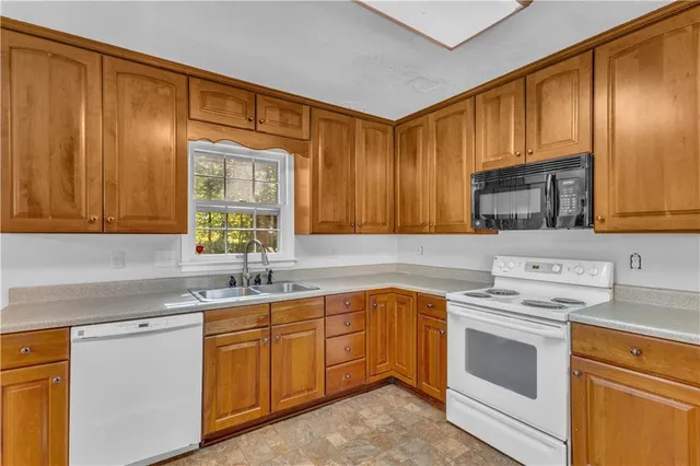 a kitchen with a sink stove top oven and cabinets