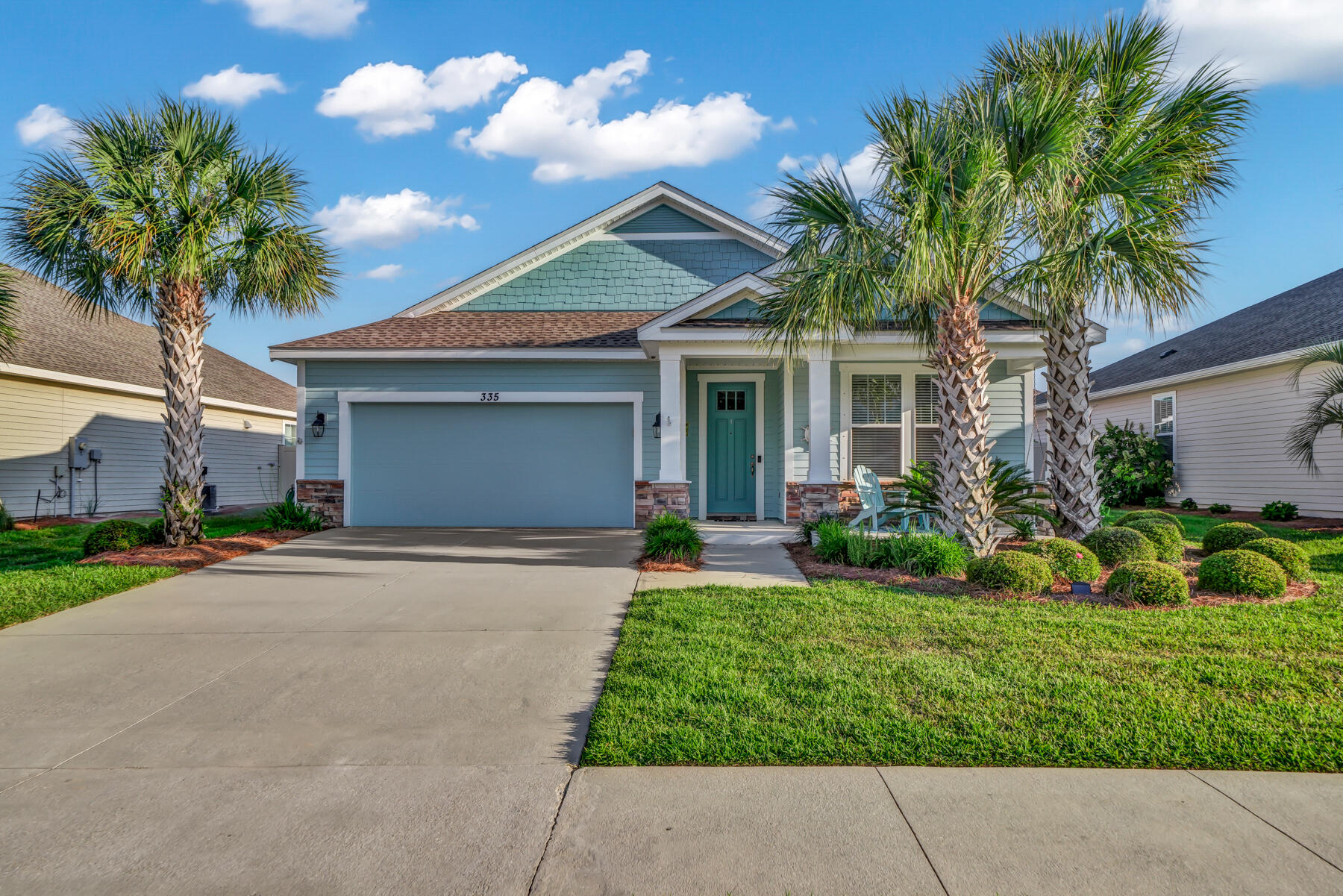 335 Blue Sage Road Panama City Beach, FL 32413 - Photo 1 of 34 a front view of a house with a yard and potted plants