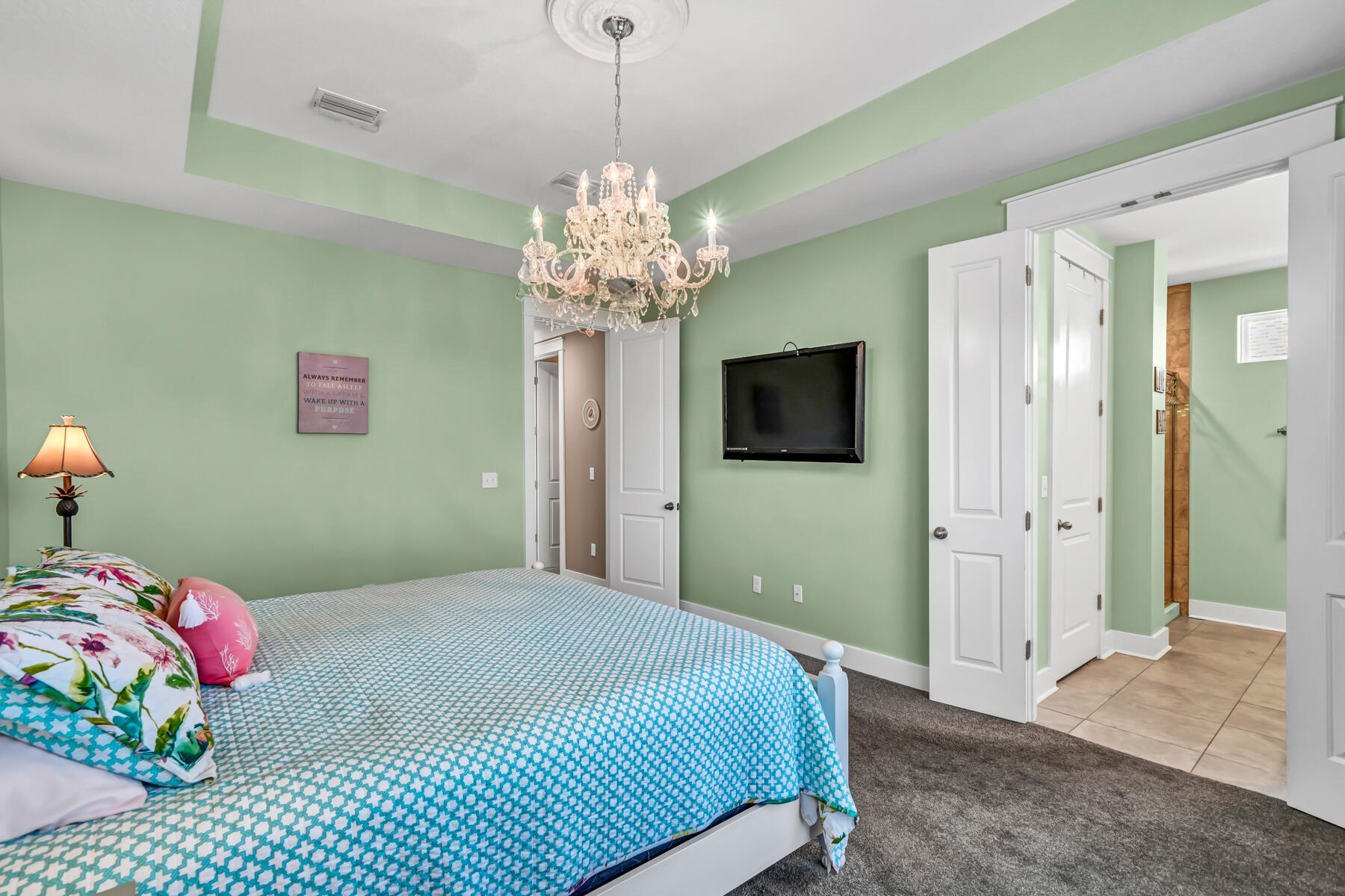 335 Blue Sage Road Panama City Beach, FL 32413 - Photo 17 of 34 a bedroom with a bed and a chandelier