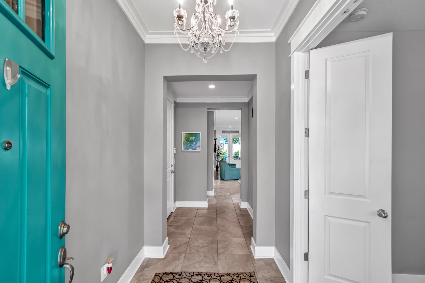 335 Blue Sage Road Panama City Beach, FL 32413 - Photo 8 of 34 a view of a hallway with wooden floor and a chandelier