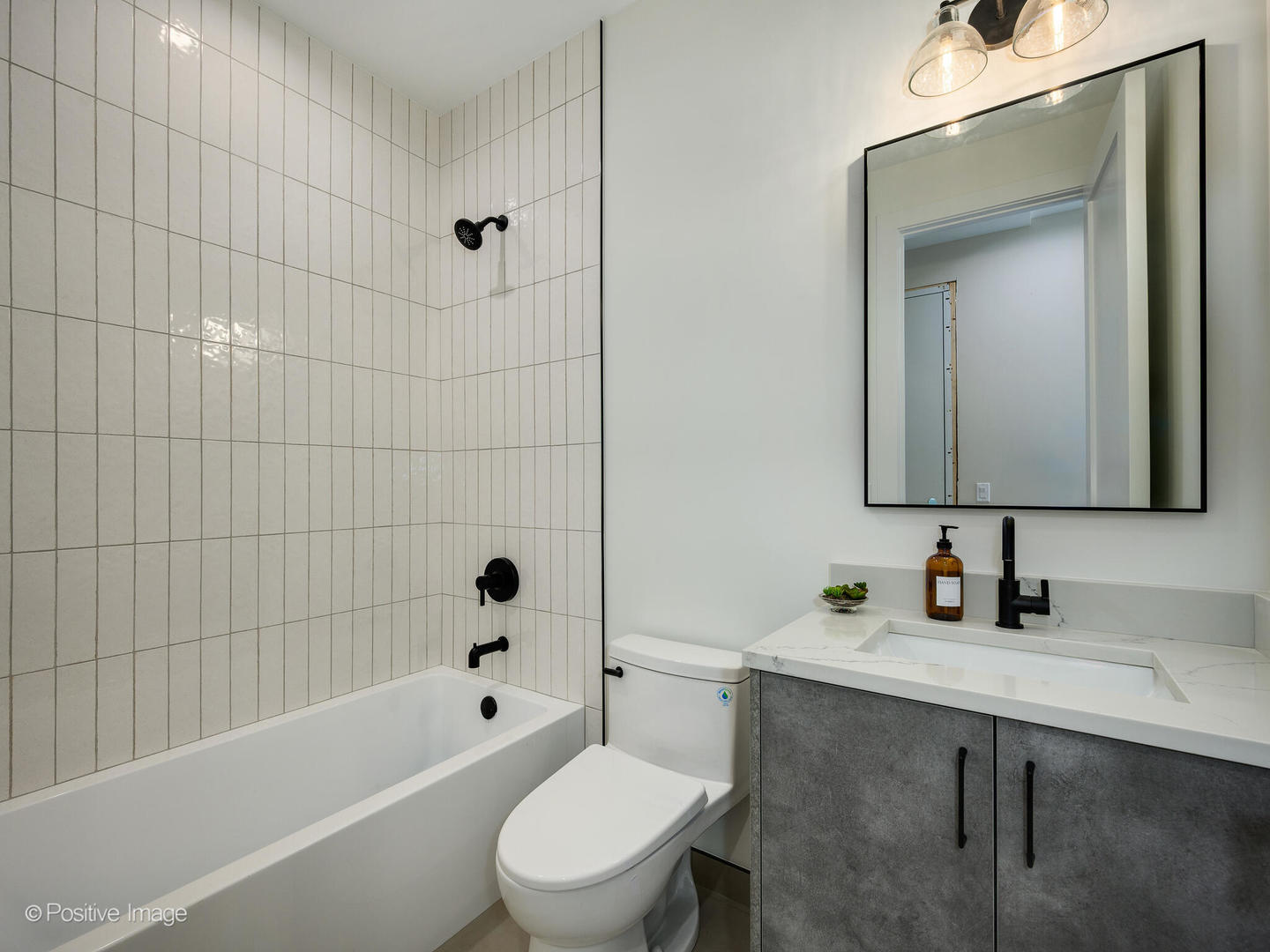 1412 North Elk Grove Avenue, Unit F Chicago, IL 60622 - Photo 15 of 23 a bathroom with a toilet sink a mirror a bathtub and shower