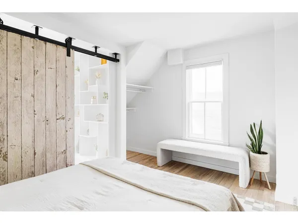 a spacious bedroom with a bed a couch and a window