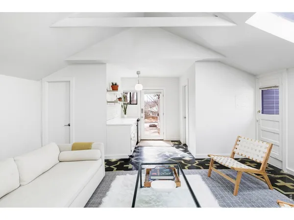 a living room with furniture a rug and white walls