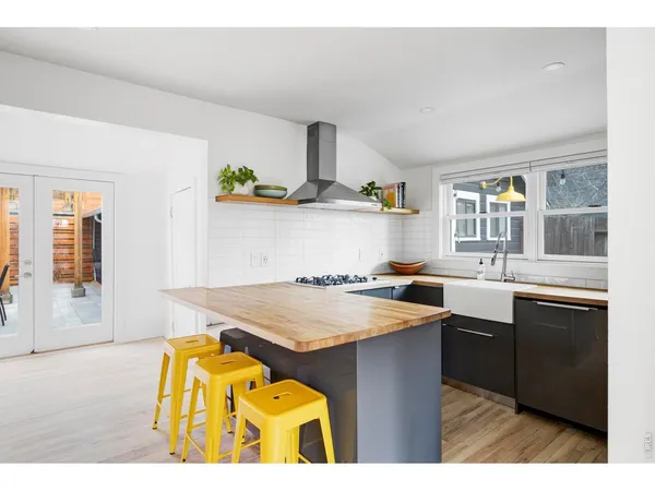 a kitchen with a sink a stove cabinets and a dining table