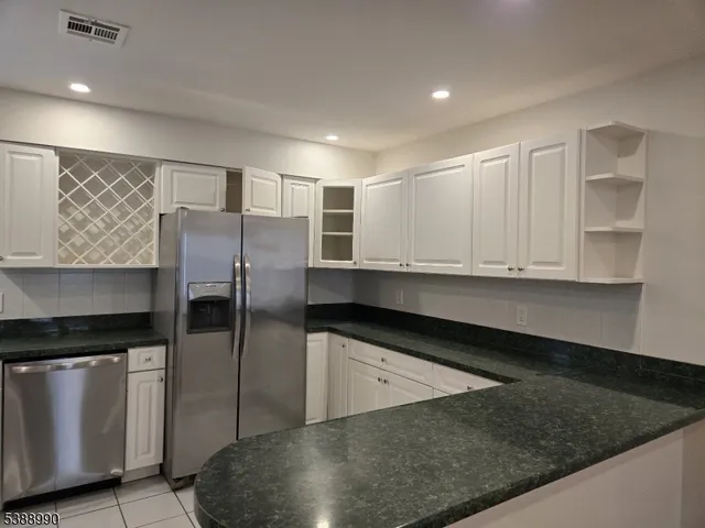 a kitchen with granite countertop a refrigerator and a sink