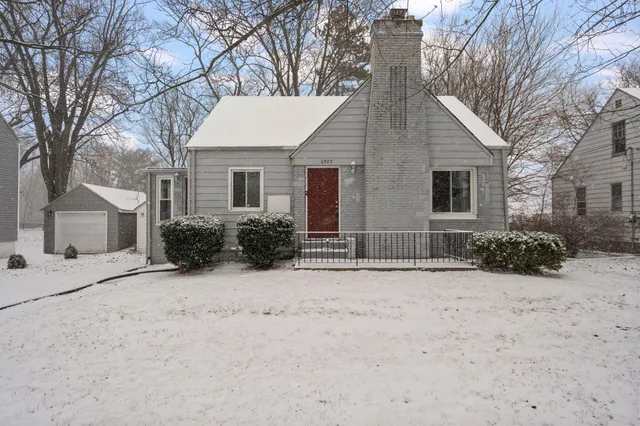 a view of a white house with a yard covered in snow