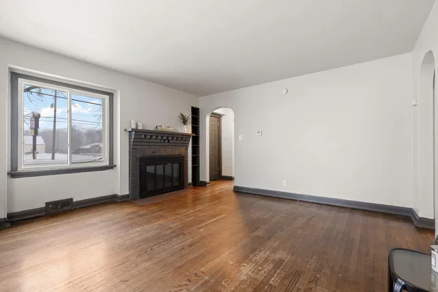 an empty room with windows and fireplace