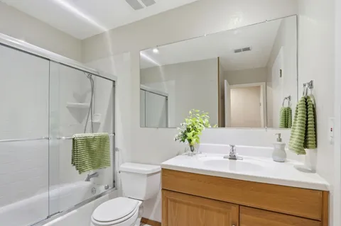 a bathroom with a granite countertop sink toilet a mirror and shower