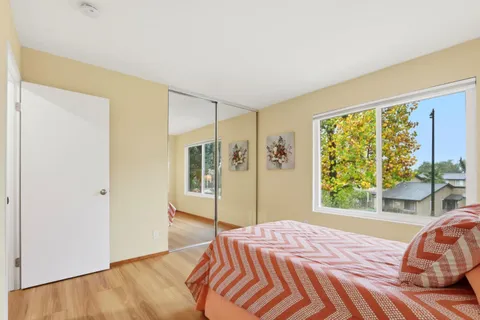 a bedroom with a bed and a large window