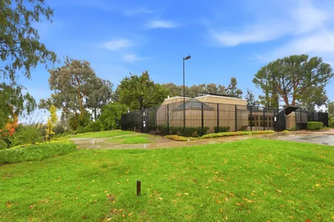 a big yard with swimming pool in front of it