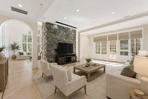 a living room with furniture a flat screen tv and a large window