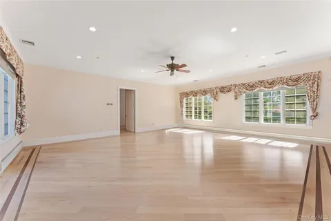 a view of a big room with wooden floor and windows