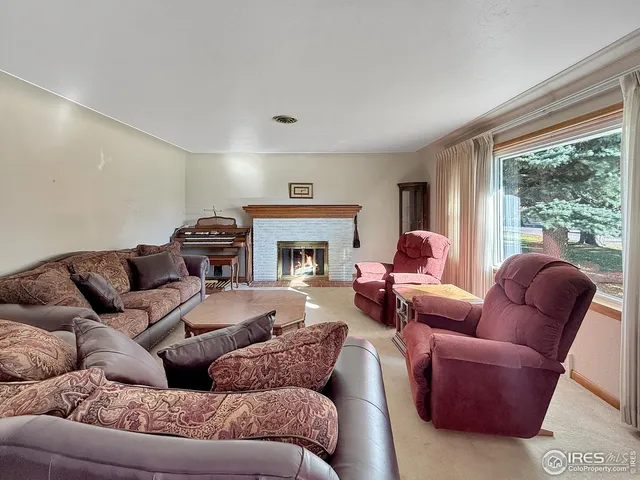 a living room with furniture a large window and a fireplace