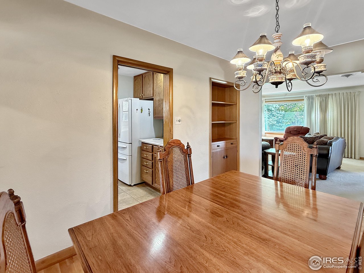 508 Fairhurst Street Sterling, CO 80751 - Photo 7 of 39 a dining room with wooden floor chandelier a flat screen tv and a chandelier