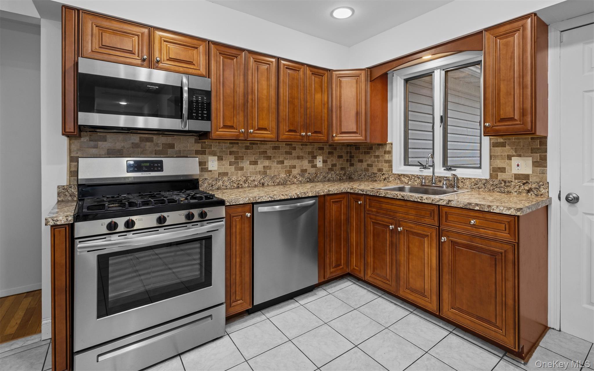 37 Pond Lane Ridge, NY 11961 - Photo 18 of 26 a kitchen with granite countertop a stove top oven microwave and cabinets