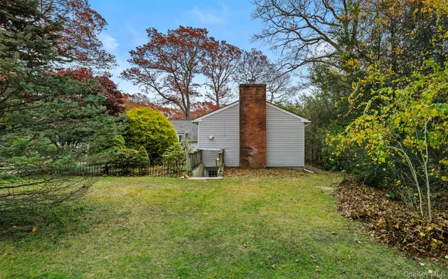 a backyard of a house with large trees and plants