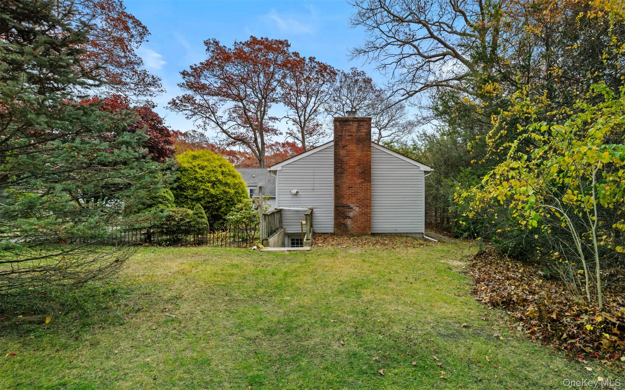37 Pond Lane Ridge, NY 11961 - Photo 4 of 26 a backyard of a house with large trees and plants