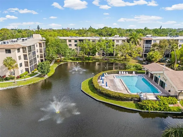 an aerial view of a house with swimming pool and lake view