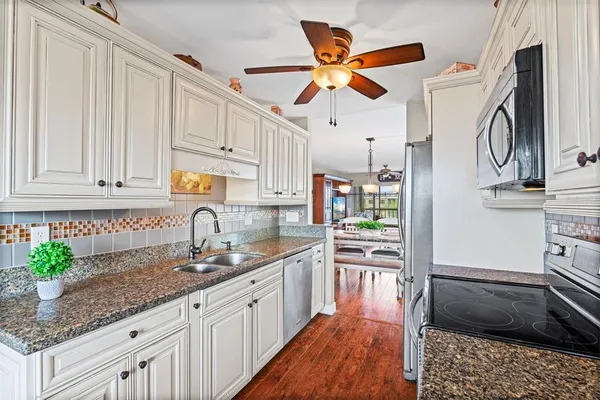 a kitchen with a sink appliances and cabinets