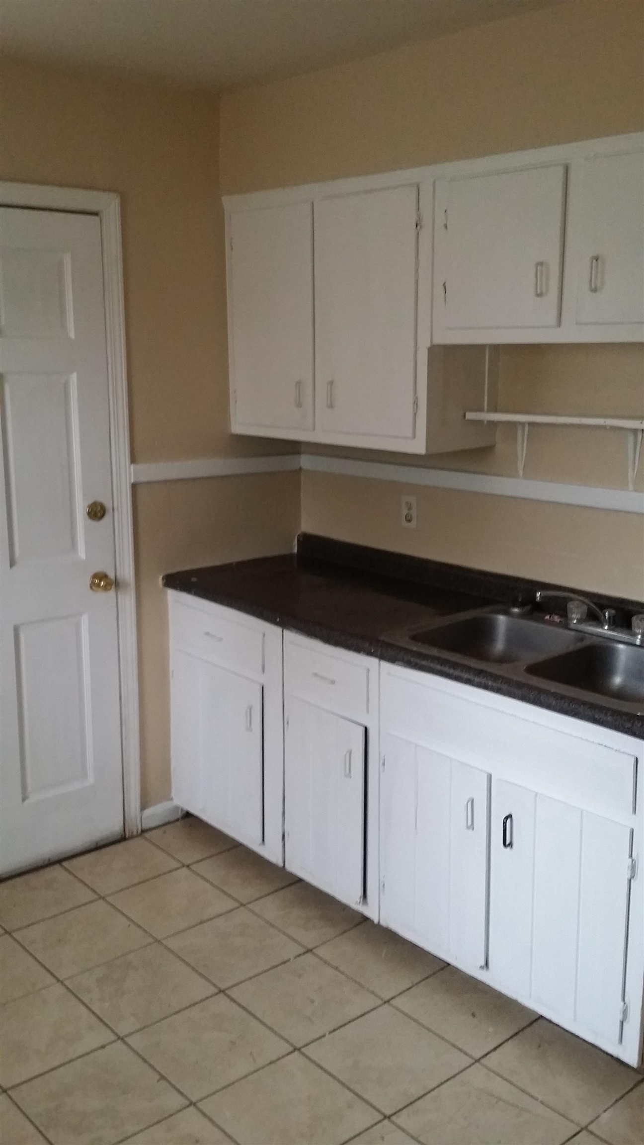 2023 Brighton Road Memphis, TN 38128 - Photo 6 of 21 Kitchen with white cabinets, light tile patterned floors, and dark countertops