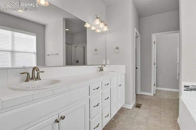a bathroom with a double vanity sink mirror and next to a window