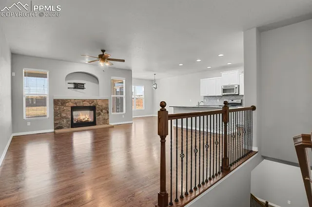 a view of a livingroom with wooden floor and a fireplace
