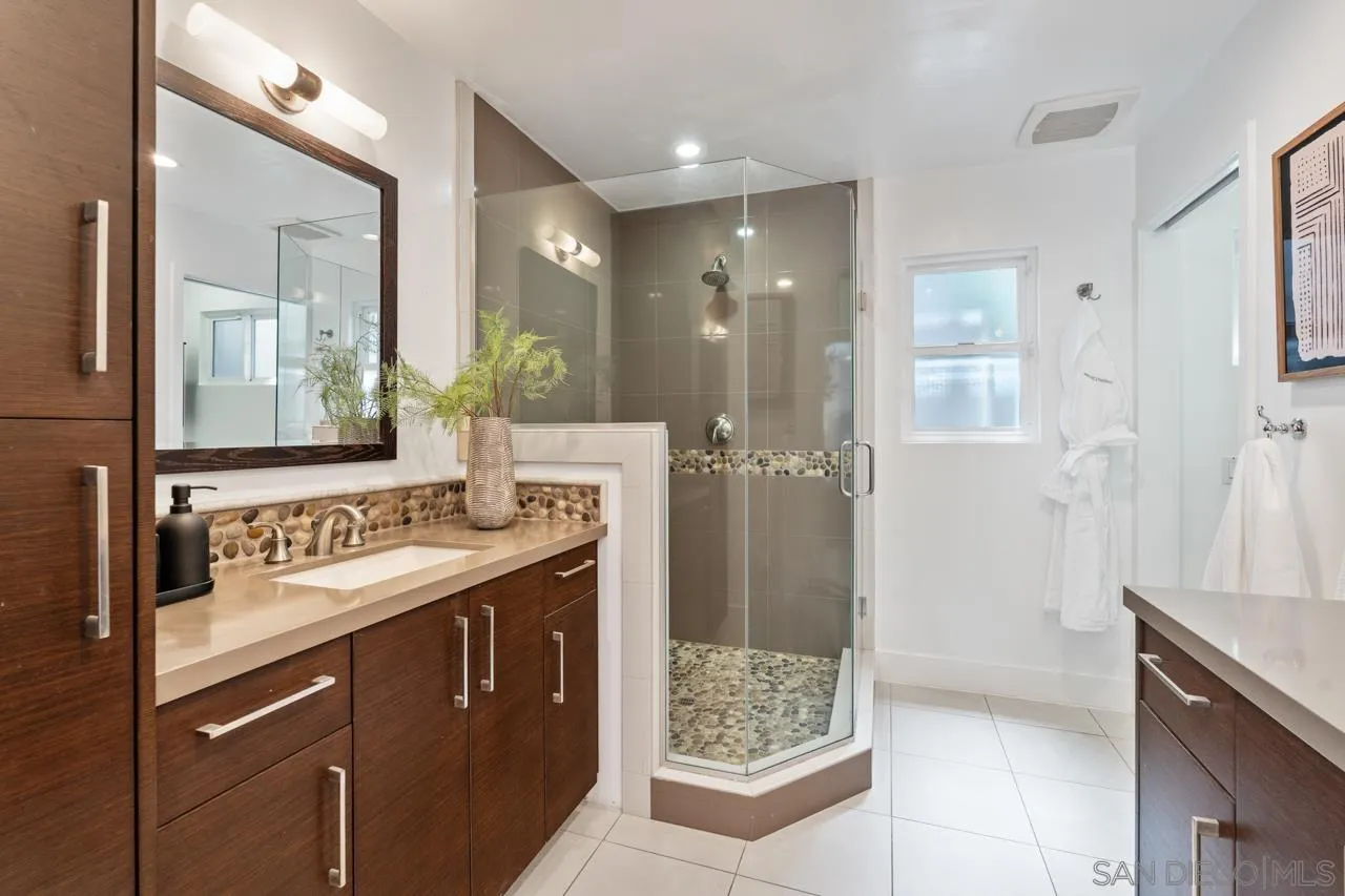 13711 Mercado Drive Del Mar, CA 92014 - Photo 32 of 46 a bathroom with a shower sink and mirror