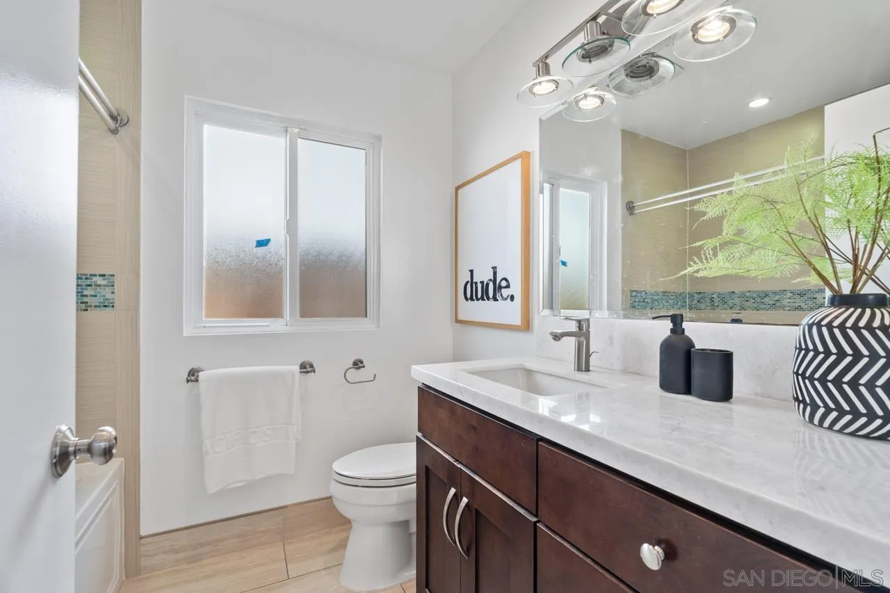 13711 Mercado Drive Del Mar, CA 92014 - Photo 38 of 46 a bathroom with a granite countertop sink a toilet a mirror and shower