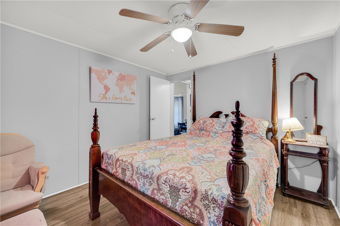 334 Lake Becky Road Mountain Rest, SC 29664 - Photo 19 of 46 A comforting bedroom features a ceiling fan, plank flooring, and a bed with a detailed frame.