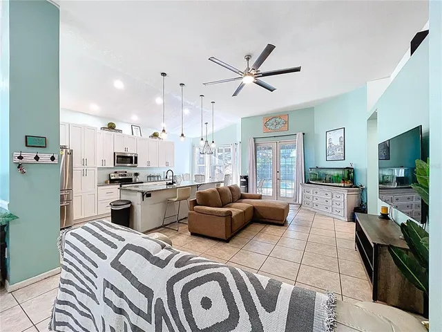 a kitchen with stainless steel appliances granite countertop a sink a stove a refrigerator cabinets and chairs