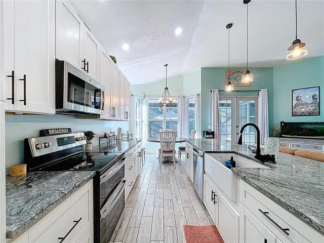 a kitchen with lots of counter top space a sink appliances and cabinets
