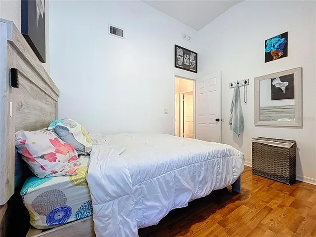 a bedroom with a bed and wooden floor