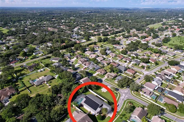 an aerial view of residential houses with outdoor space and trees