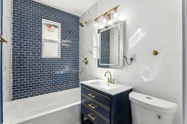 a bathroom with a sink mirror bathtub and toilet