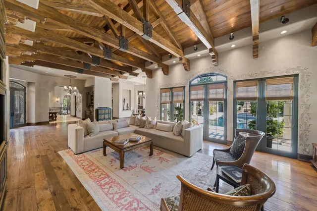 a dining room with wooden floor a chandelier a wooden table and chairs