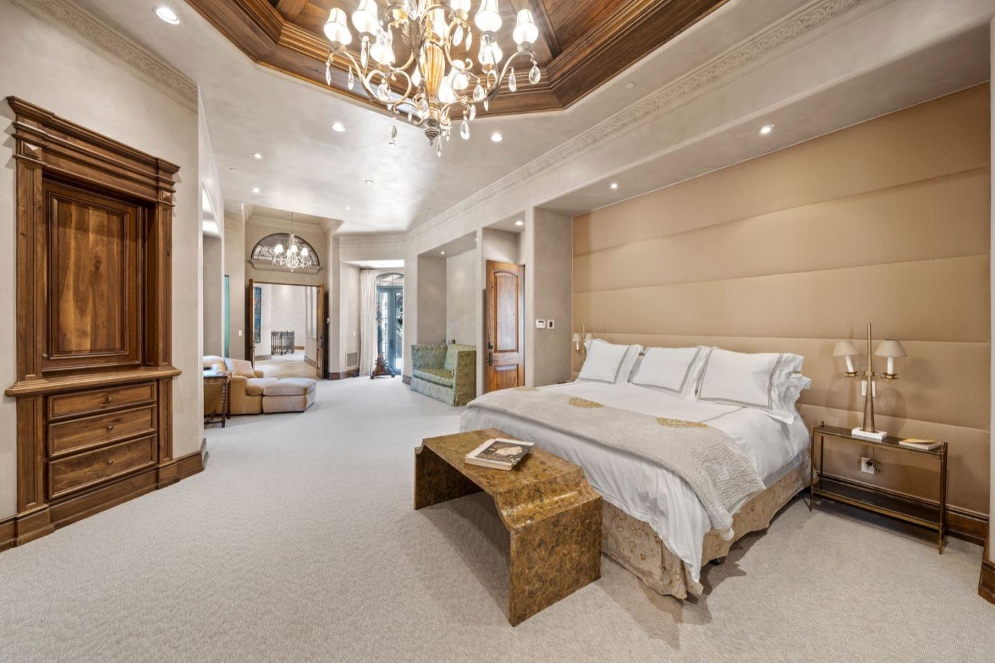 25751 Elena Road Los Altos Hills, CA 94022 - Photo 32 of 80 a spacious bedroom with a bed and a chandelier