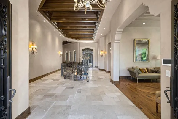 a living room with couches a table and a chandelier