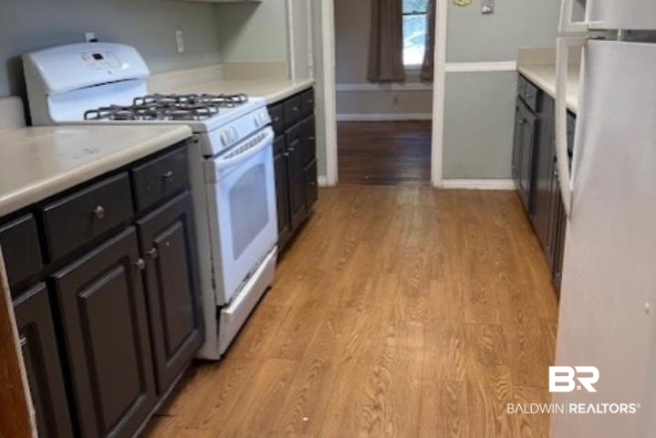 1809 Harris Road Mobile, AL 36618 - Photo 4 of 11 Kitchen with white appliances, light wood finished floors, and light countertops