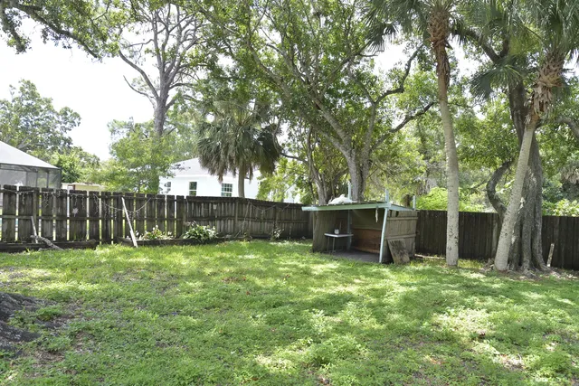 a view of a backyard with a small cabin and wooden fence