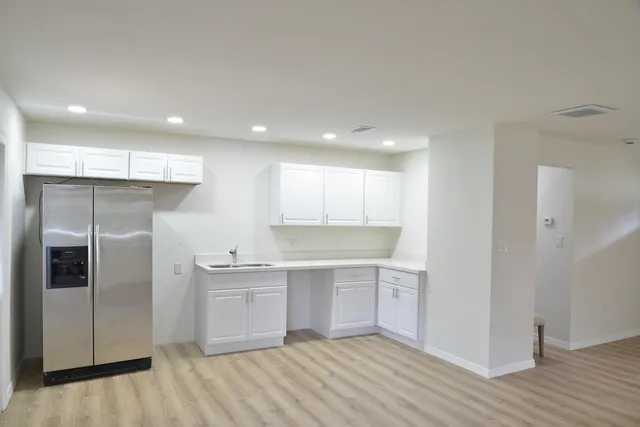 a kitchen with white cabinets and stainless steel appliances