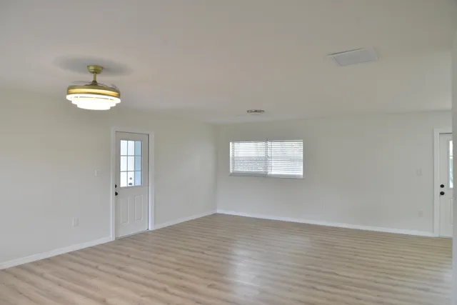a view of empty room with wooden floor