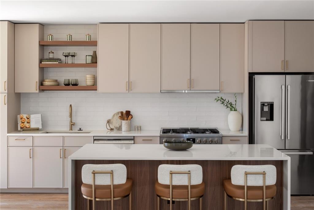 1081 Juniper Street Northeast, Unit S2C Atlanta, GA 30309 - Photo 11 of 46 a kitchen with a sink a refrigerator and cabinets