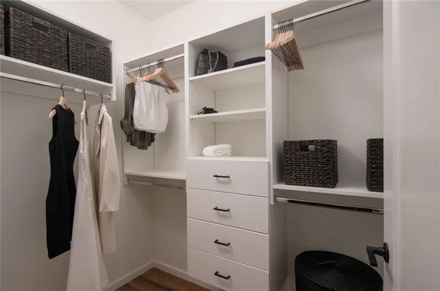 a view of walk in closet with clothes and shoes